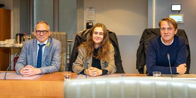 2 jongeren poseren voor de foto met minister Mathias Diependaele in een commissiezaal van het Vlaams Parlement